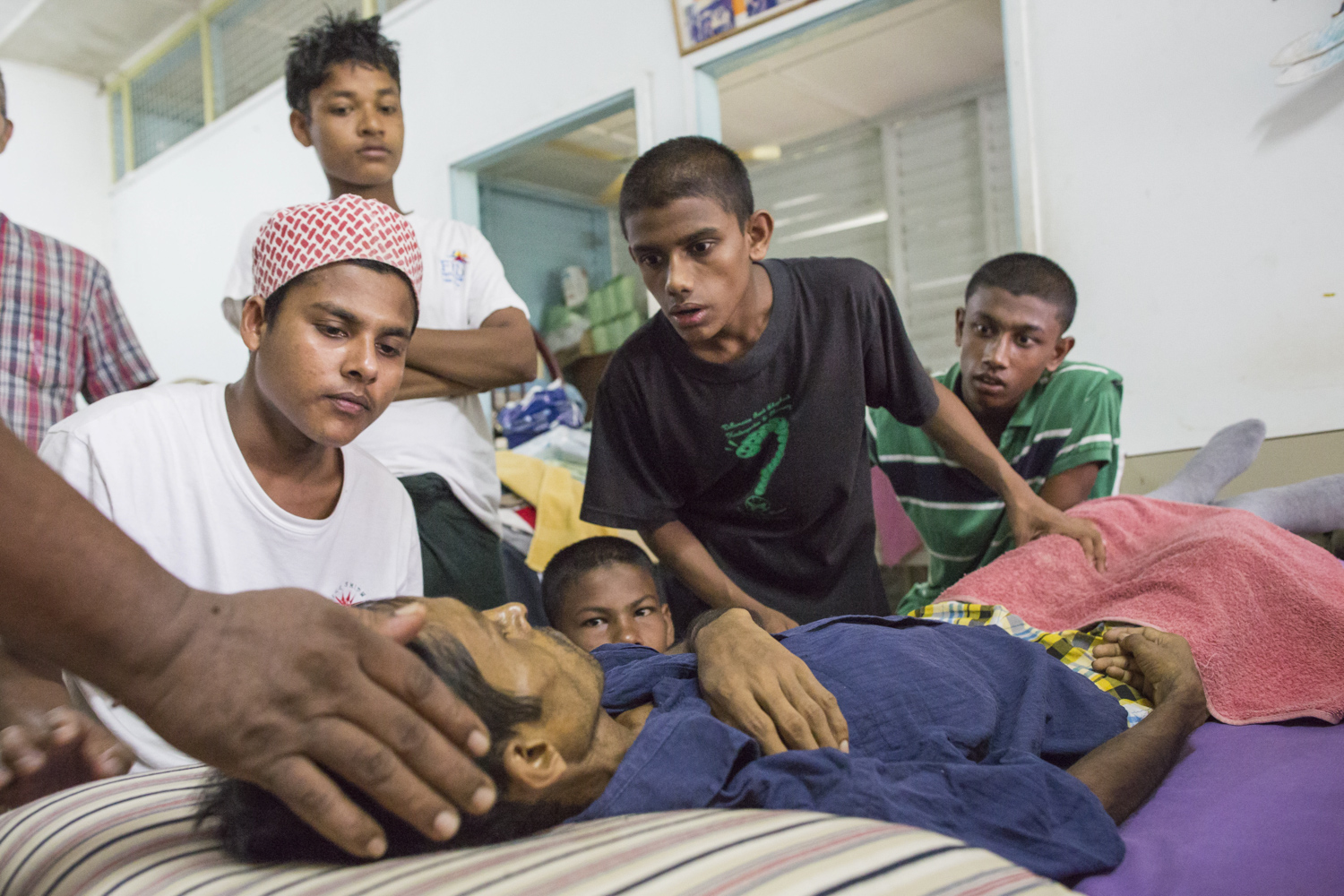 Alex and the Rohingya boys watching over Rashedul as his blood pressure drops dangerously low. Rashedul was terminally ill with liver cancer, and needed palliative care.