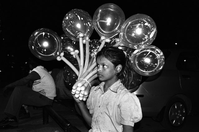 GIRL WITH BALLOONS: Ten-year-old Lachhi sells balloons on a busy weekend night at Delhi's India Gate, a popular picnic spot