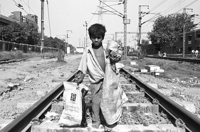 CARRYING BAGS: Rag picking can be a dangerous trade. This 12-year-old boy walks the length of for a choice pick