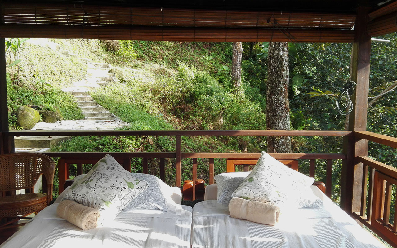 There are no walls between your bed and the trees around you - just wooden rails and bamboo screens that can be lowered for privacy. Photo from Green Acres Orchard and Ecolodge