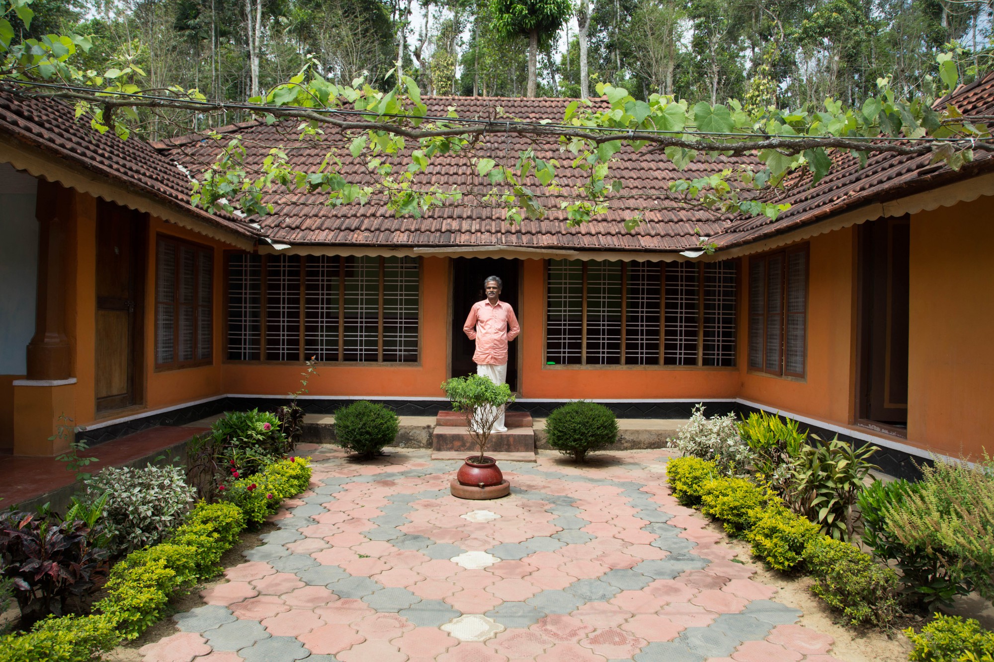Kesavan stands proudly in front of his home. The home he was born in and the home her granddaughter Niranjana will grow up in. Photo by Gayatri Ganju.