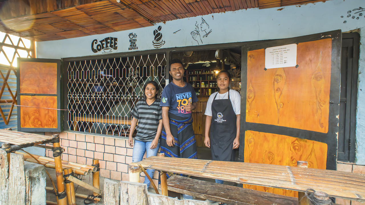 The entrance of Lepa Lio Cafe, set up by RMC, where travellers can enjoy a cuppa. Standing in front of the cafe are (from left) Eupracia Pai, Nando and Imelda Ndimbu. Eupracia and Imelda are working at Lepa Lio while undergoing training in artisanal food production. Photo by Andra Fembriarto