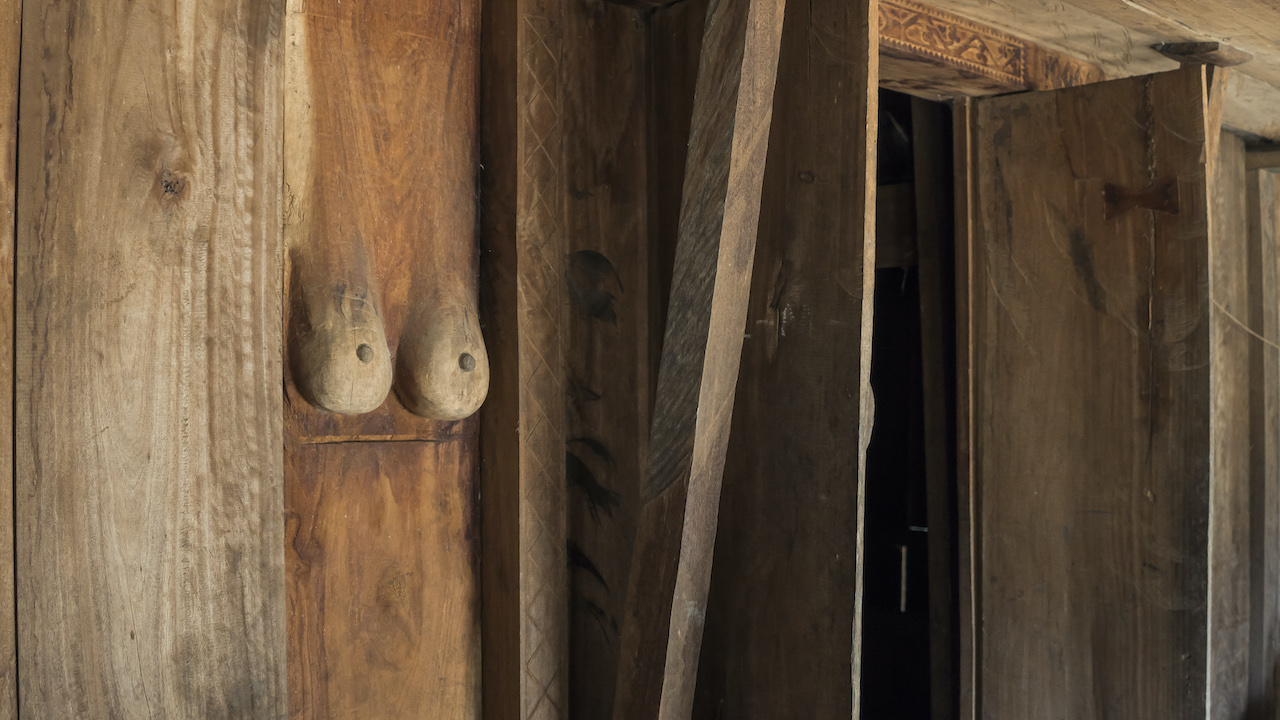 A pair of female breasts carved near the entrance of a traditional Lio house. The touching of these breasts is part of the invitation ritual into a Lio house. Photo by Andra Fembriarto
