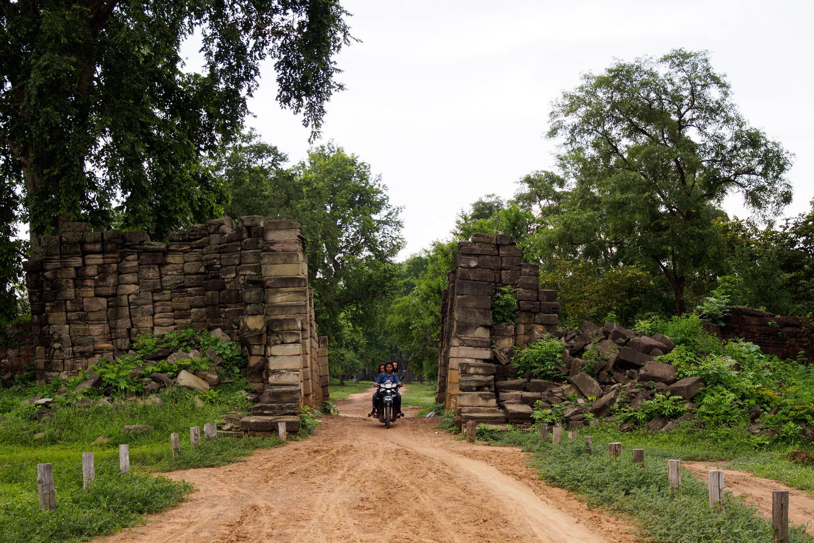 A group of local women ride a motorbike through the stone gates of Banteay Chhmar temple. Photo by Emily Lush