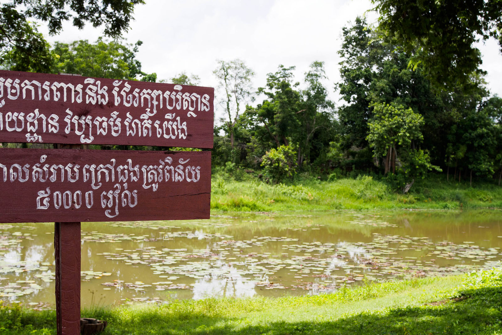 The moat is the first thing most people see when entering Banteay Chhmar. This sign encourages people not to litter and to keep the area clean. Photo by Emily Lush