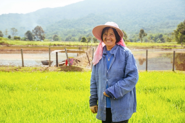 Aunty Ribed, standing in front of a paddy field in Long Semadoh, Sarawak