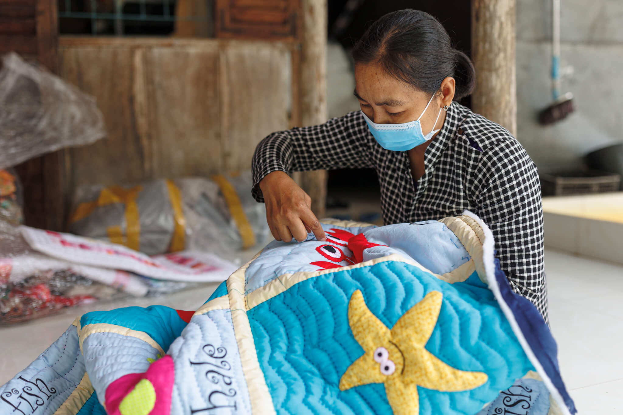 A woman works on a quilt in the Mekong Delta