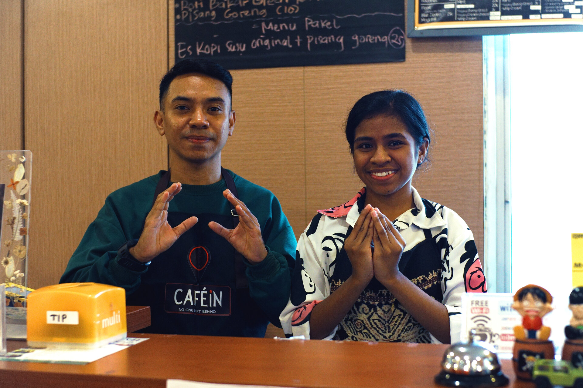 Barista Tanel Loa and cook An Mone sign Inklusi (inclusive) in the BISINDO sign language. 