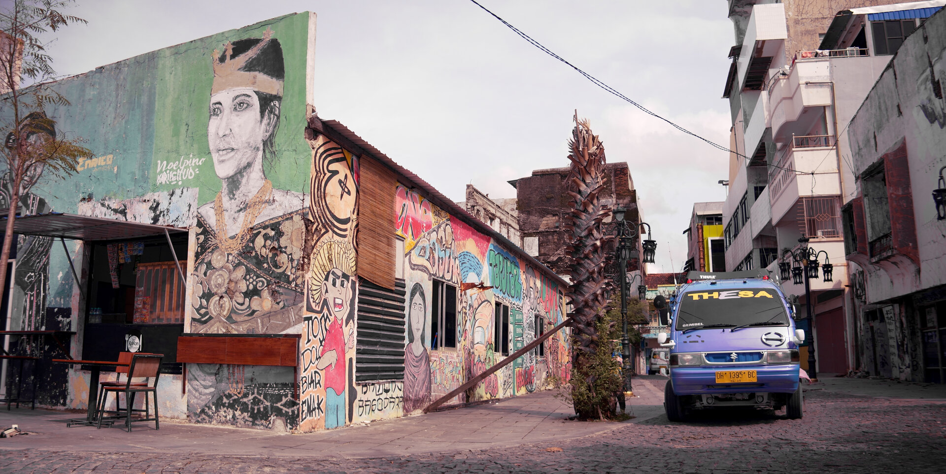 Murals in the Old City. The Noelpino mural in the foreground portrays a Rotinese woman, a group not indigenous to Kupang, but the city is home to a sizable Rotinese diaspora, many of whom have resided in Old Kupang for centuries.