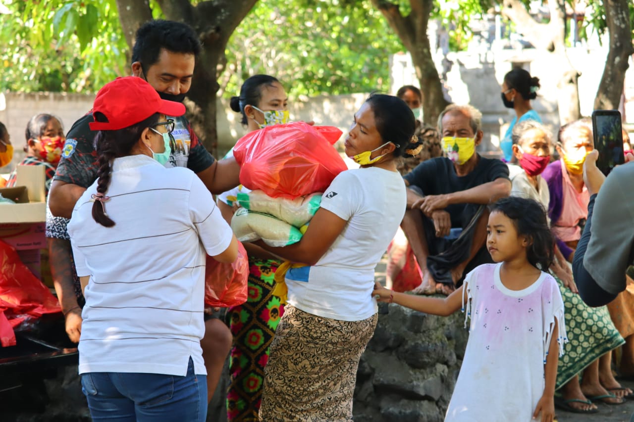 A woman collecting bags of rice, vegetables and provisions given out by Feed Bali, an initiative by Tresna Bali Cooking School to give out food to communities in need. 