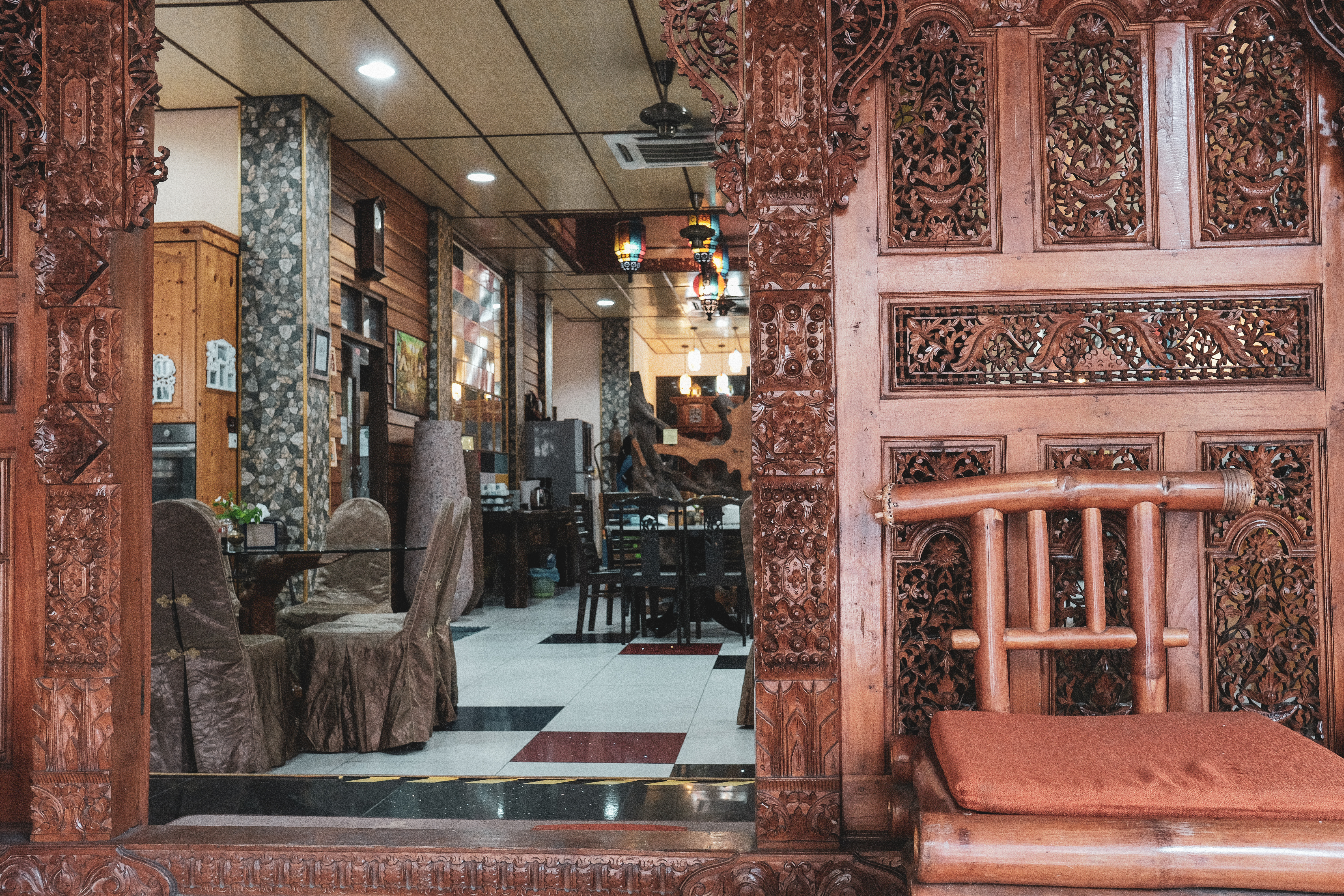 This intricately carved door from Bali welcomes guests to enter the dining room, which houses the reception too.