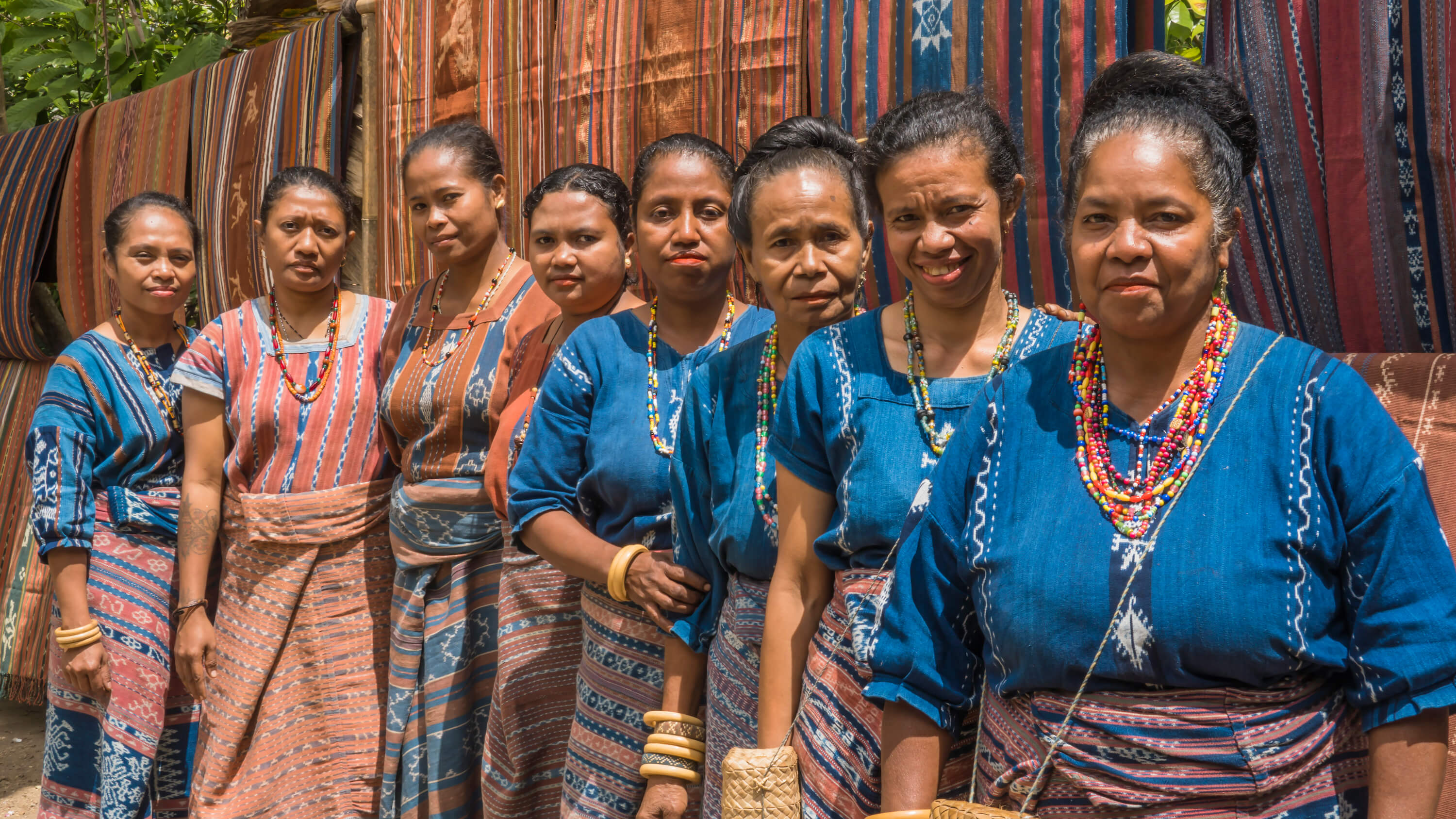 Members of Watubo stand before their woven creations: (left to right) Maria Genisa, Rosvita Sensiana, Maria Elviana, Maria Suwanti, Nona Eta, Maria Roslina, Maria Goreti and Virgensia Nurak. The workshop is designed to immerse travellers in Sikka’s weaving heritage. Photo by Andra Fembriarto