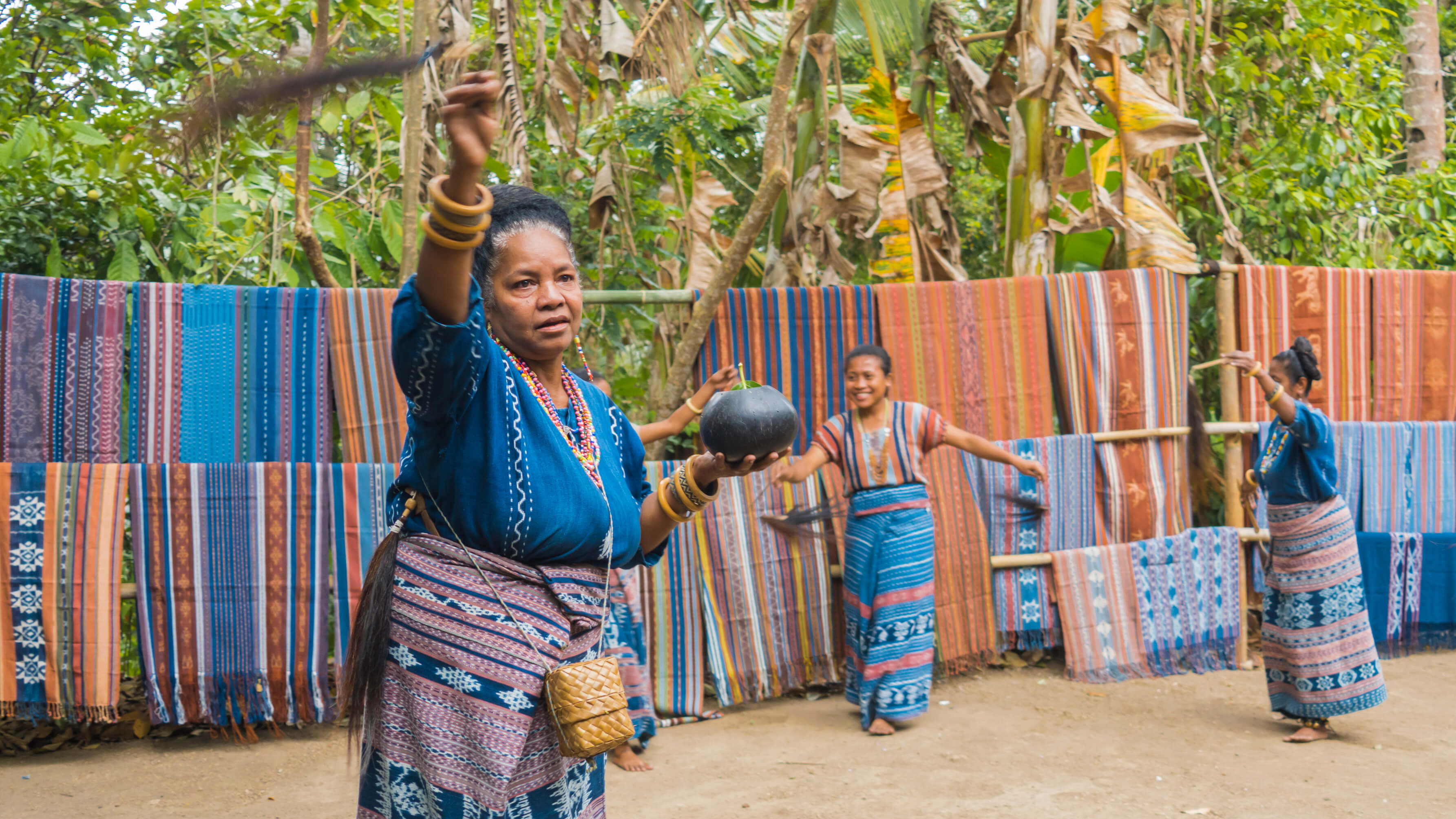 Virgensia Nurak (foreground) performs a welcome dance for guests with a ritual sprinkling of water from a brush. Photo by Andra Fembriarto