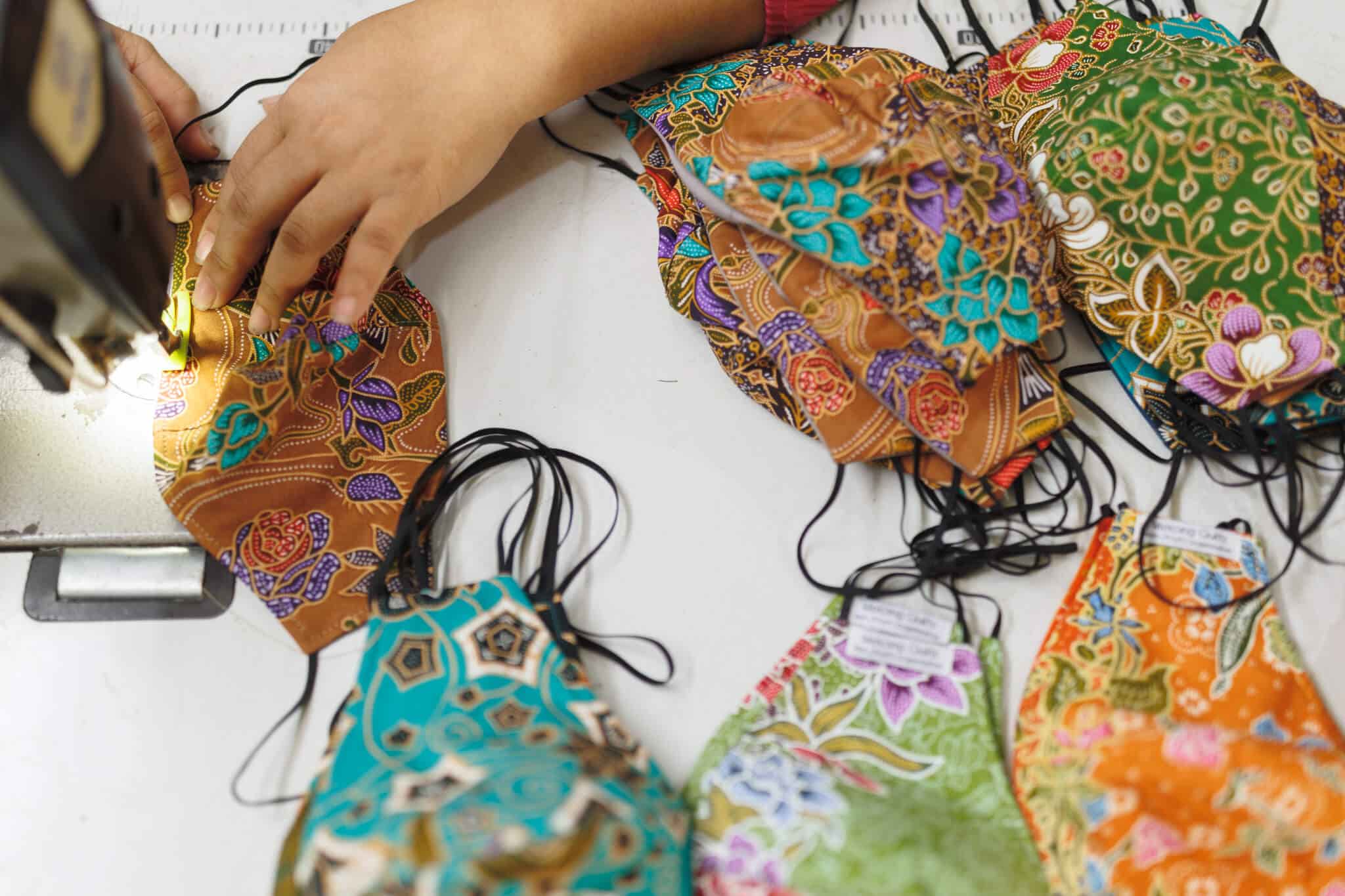 Handmade batik-print masks on a table.