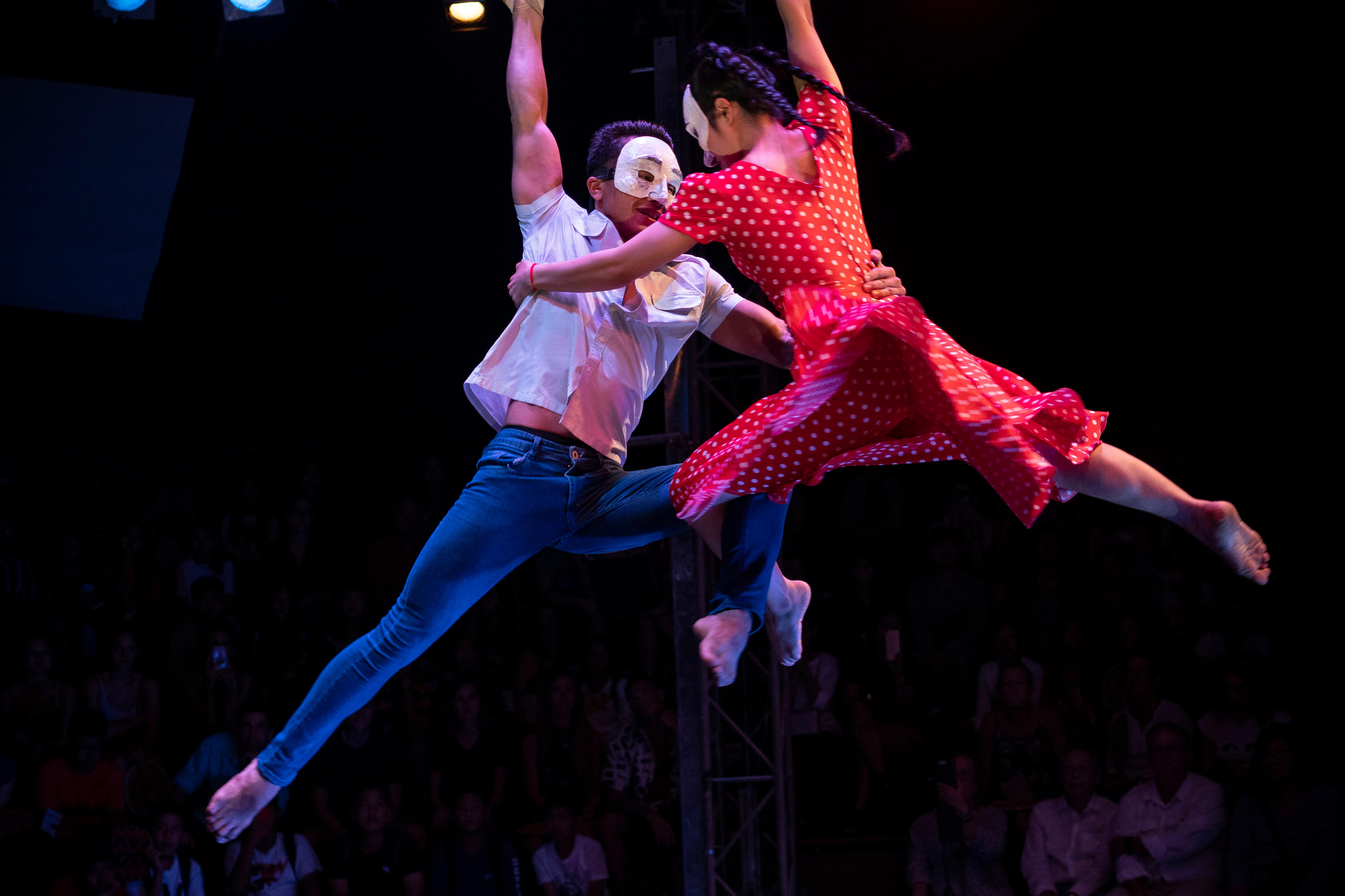Two circus artists are suspended from ropes as they perform an aerial stunt at Phare circus