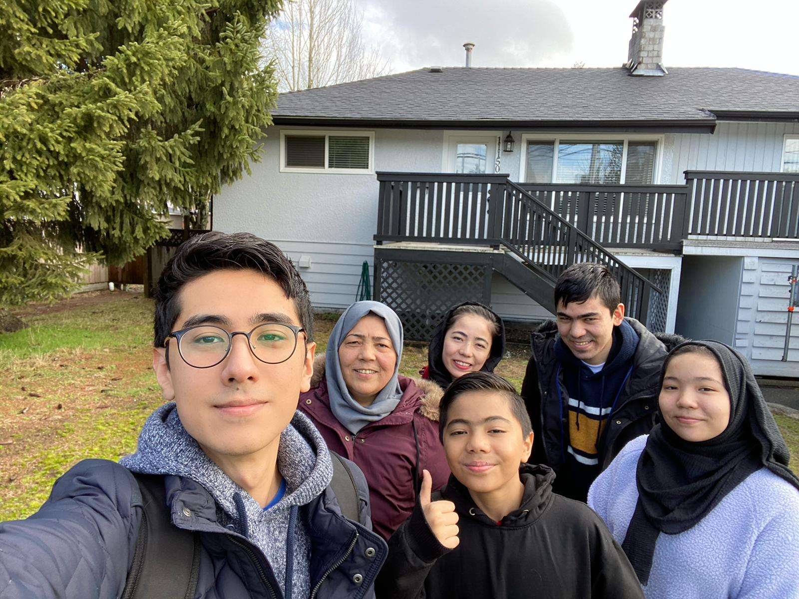 Abdullah and his family in front of their new home in Vancouver, Canada