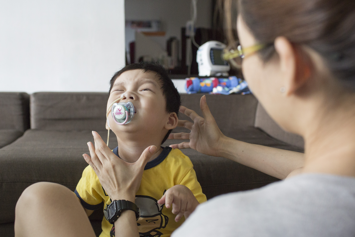 As part of their daily morning routine, Lowell sits with Caelen to guide him through a session of independent sitting to strengthen his core muscles. Having poor balance and weak trunk control, he has difficulty sitting up straight on his own