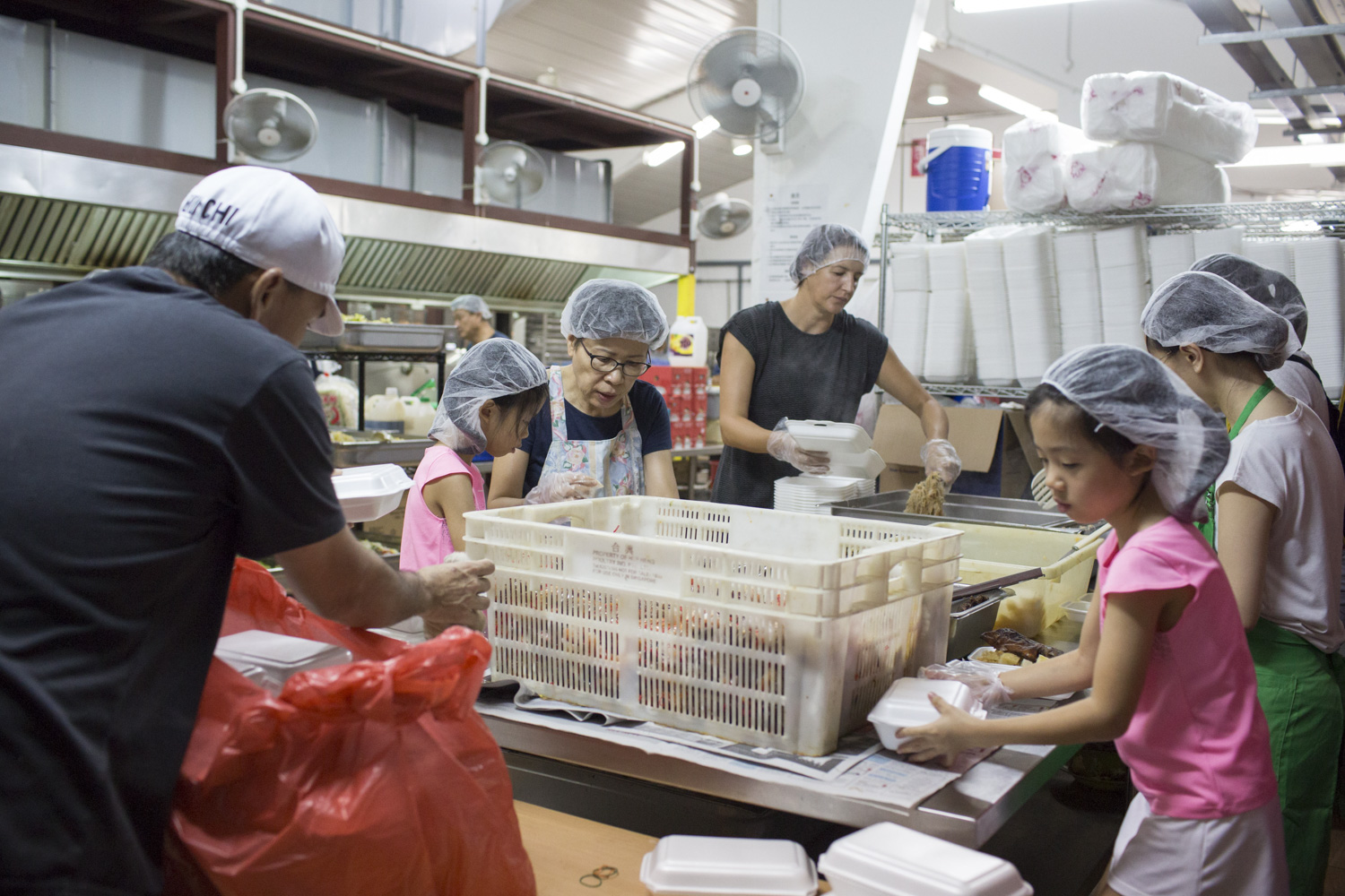 The girls make themselves useful, diving right into the heat of activity with other volunteers in the kitchen.