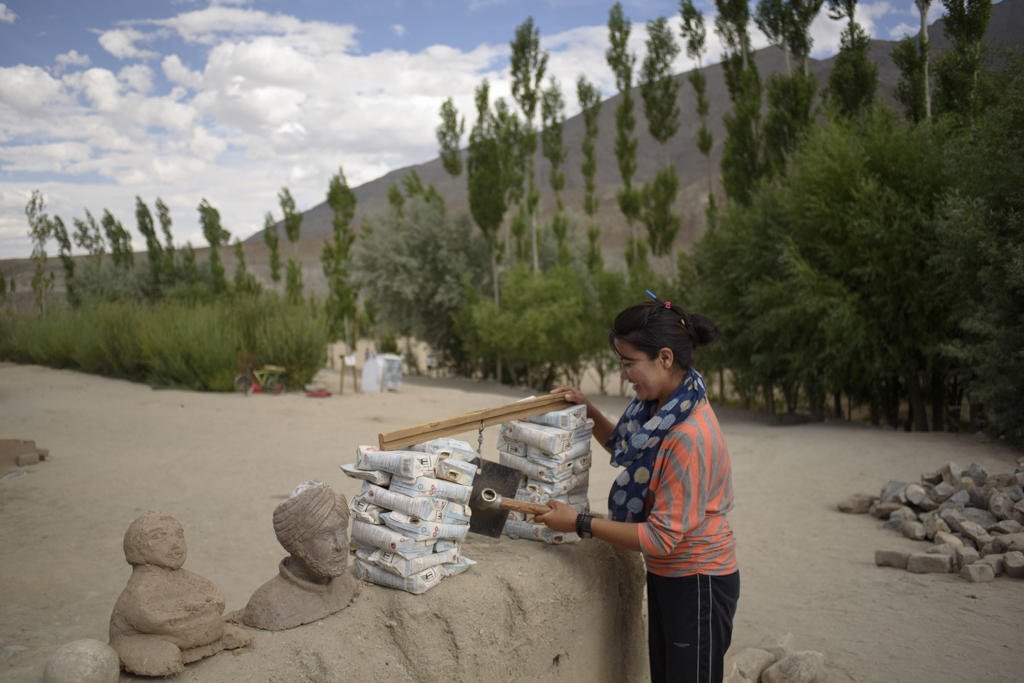 A student rings a bell made of reused juice cartons and metal bearings. Being an eco school, SECMOL promotes recycling and the use of recycled products.