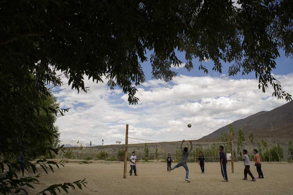 Students enjoy a game of volleyball in the field.