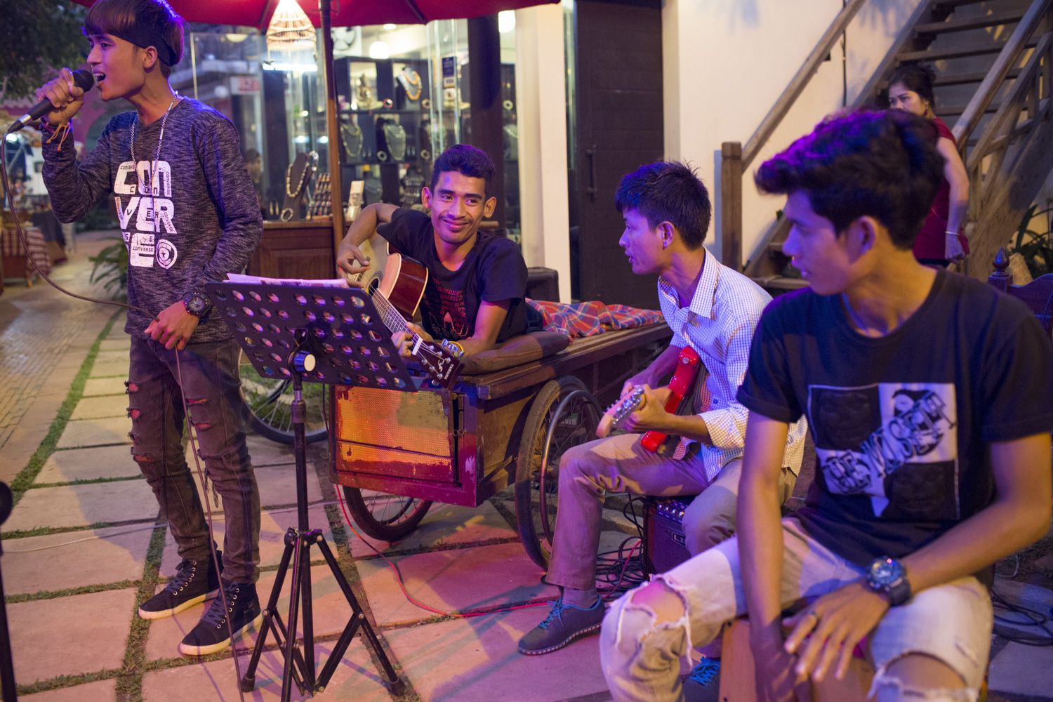 On Friday evenings, Sophanna performs with his acoustic band at an outdoor craft market in King’s Road Angkor, Siem Reap, Cambodia. Apart from writing songs, he teaches music for free, and eventually formed a band with some of his students. On Friday evenings, Sophanna performs with his acoustic band at an outdoor craft market in King’s Road Angkor, Siem Reap, Cambodia. Apart from writing songs, he teaches music for free, and eventually formed a band with some of his students.