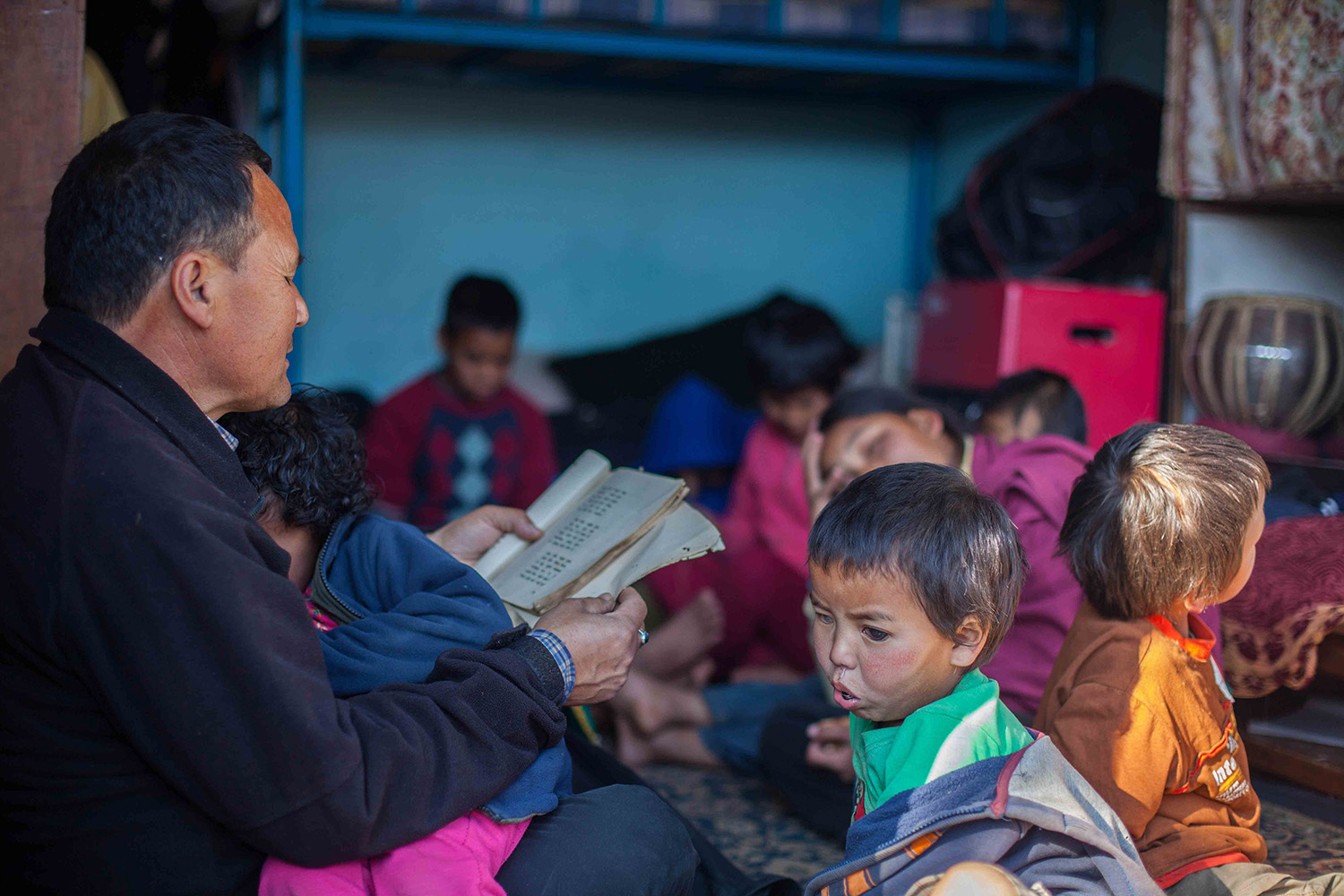 Running the school is a busy job, but Dayaram finds time to read to the children