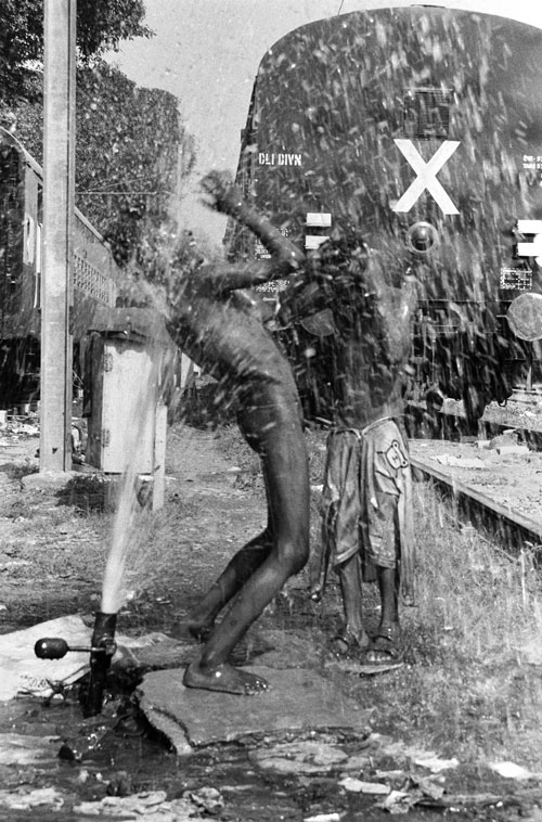 BATHING AT THE STATION: A broken water line on a hot summer day provides a real treat for children living on the street