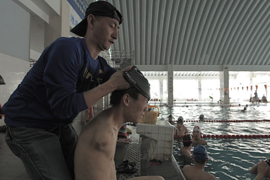 Lending a hand: Coach Li Keqiang, who lost his left forearm to an electric cable at a young age, expects his swimmers to be independent, but also offers help when needed