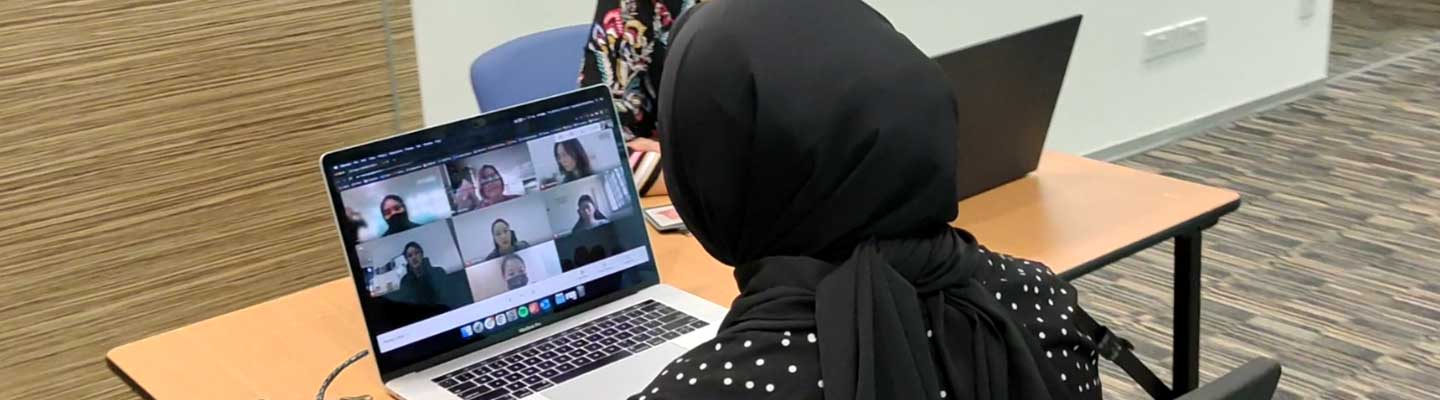 Lady looking at a video conferencing screen on her laptop