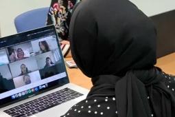 Lady looking at a video conferencing screen on her laptop
