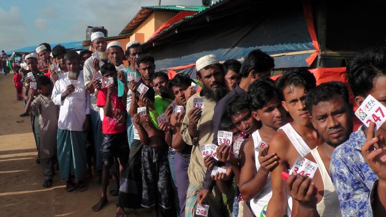 Refugees living in Cox's Bazar form a long line as they wait to collect food items and necessities being distributed by Free Food for All in 2018. 