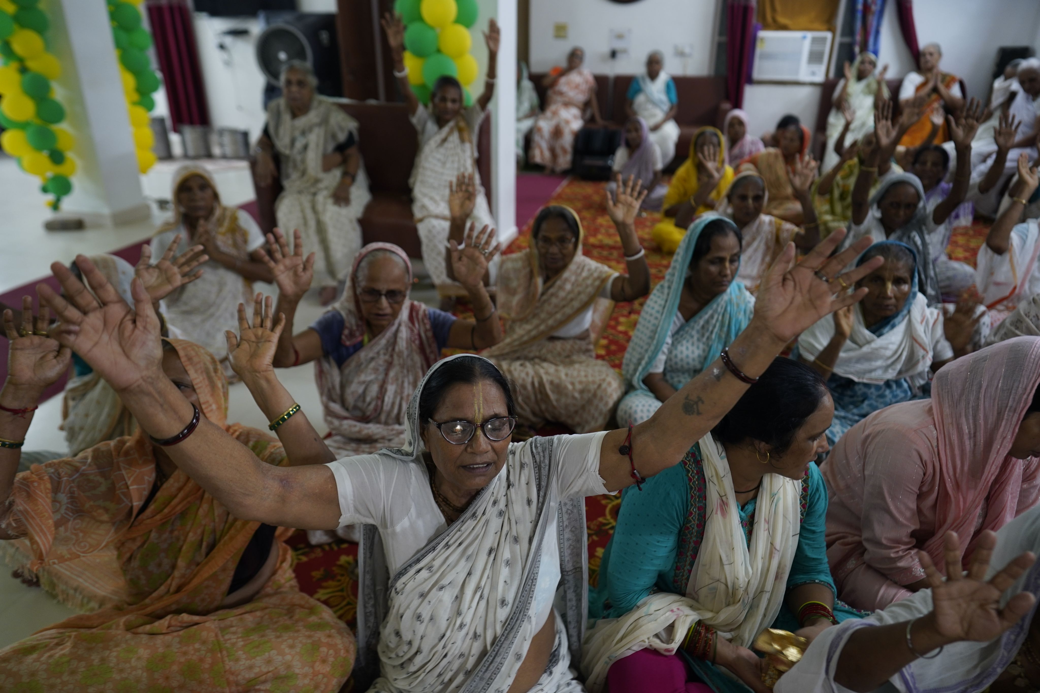 The ashram's residents find solace in daily rituals such as religious song and dance.